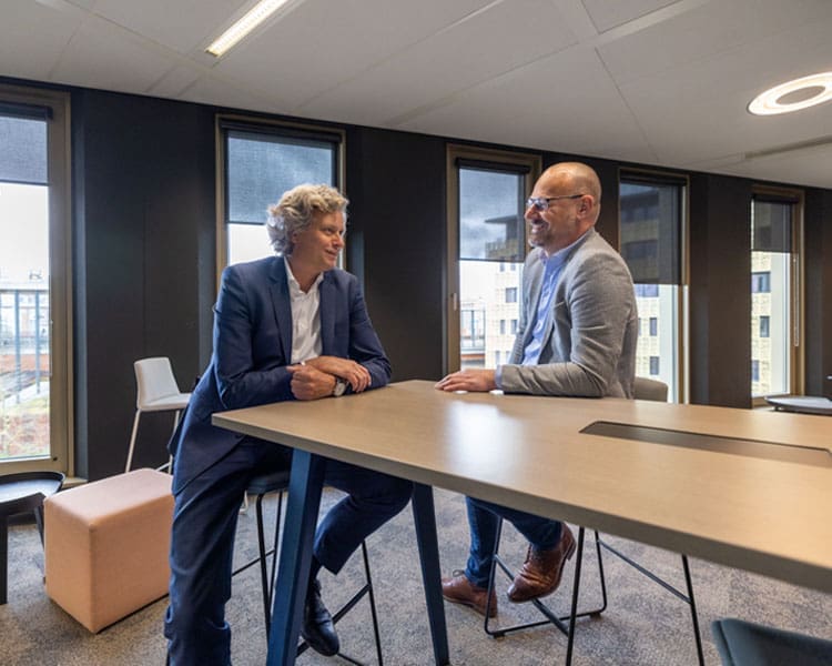 Twee collega's lachen en communiceren met elkaar