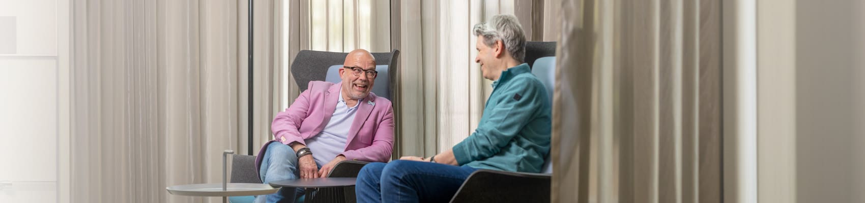 twee medewerkers lachen tijdens een gesprek