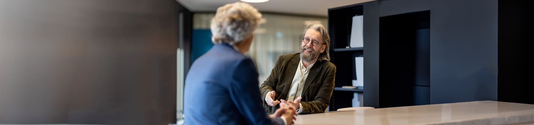 twee mannen met elkaar in gesprek aan een staantafel